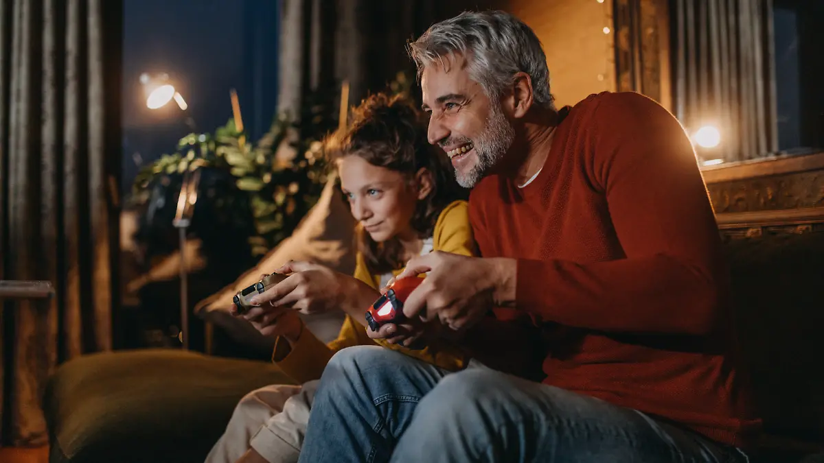 Vater und Tochter mit einer Spielkonsole.