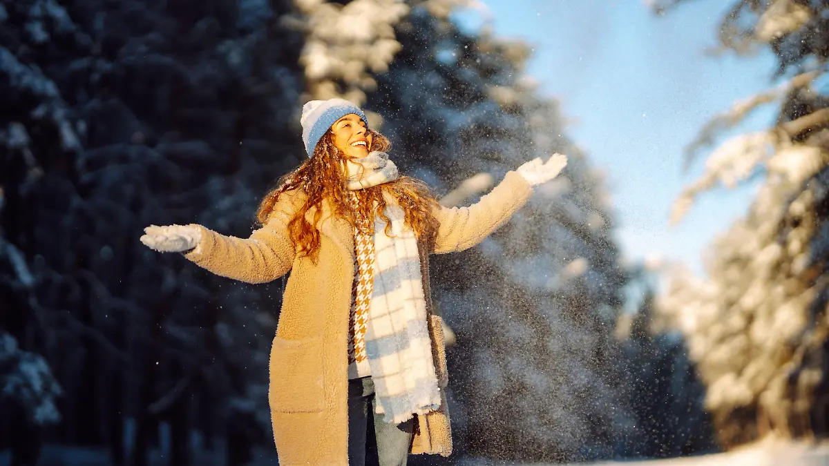 Eine Frau macht einen Winterspaziergang im Schnee.