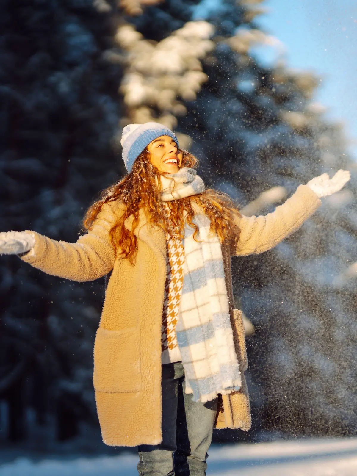 Eine Frau macht einen Winterspaziergang im Schnee.