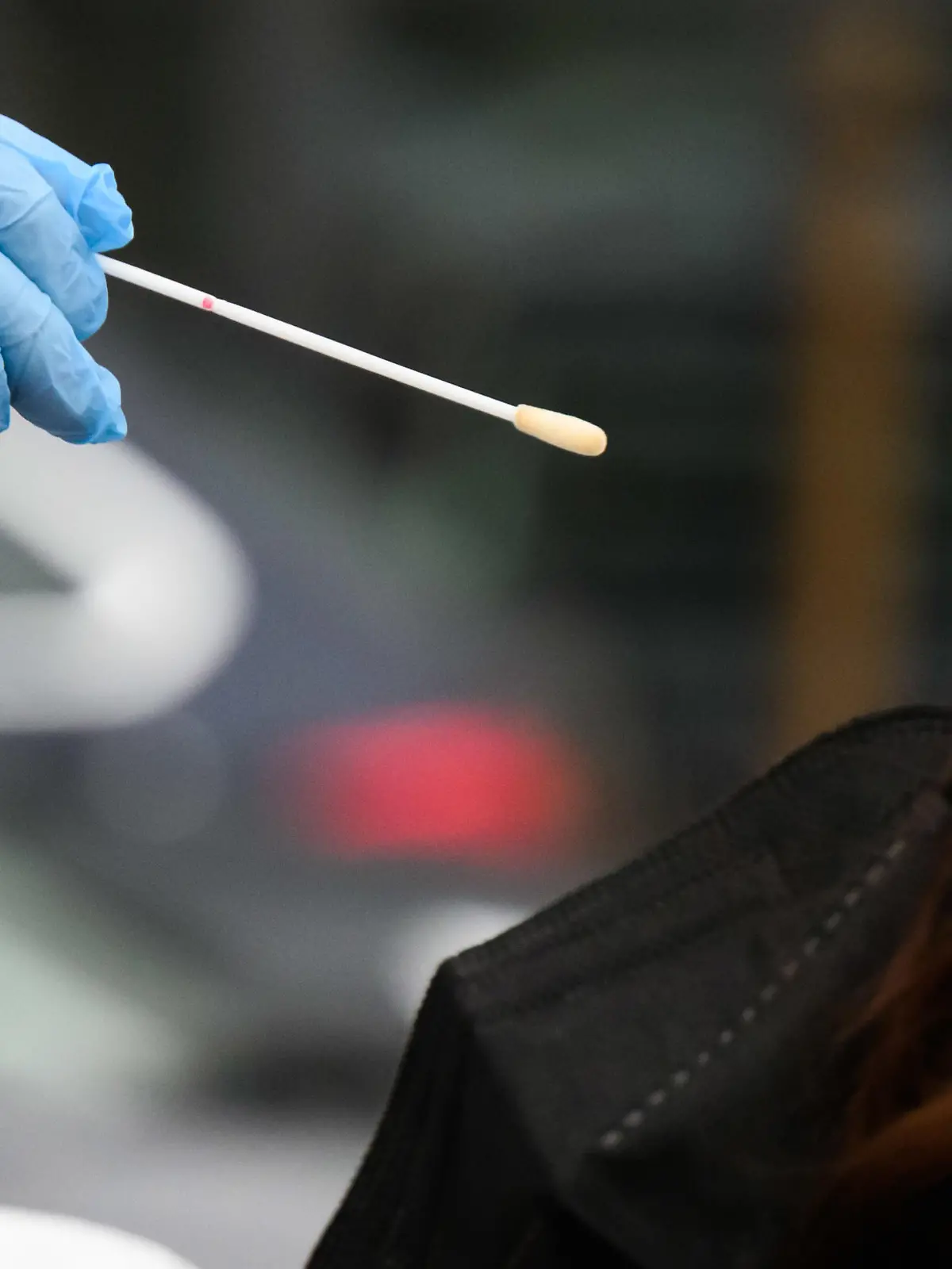 26.01.2022, Niedersachsen, Laatzen: Eine Hausärztin nimmt einen Abstrich von einer Patientin für einen PCR-Test auf das Corona-Virus vor einer Arztpraxis in der Region Hannover. Erstmals in der Corona-Pandemie sind binnen eines Tages mehr als 150 000 Neuinfektionen an das Robert Koch-Institut übermittelt worden. Wegen der sprunghaft steigenden Infektionszahlen reichen die derzeitigen Kapazitäten für die besonders genauen PCR-Tests nicht mehr aus. Foto: Julian Stratenschulte/dpa +++ dpa-Bildfunk +++