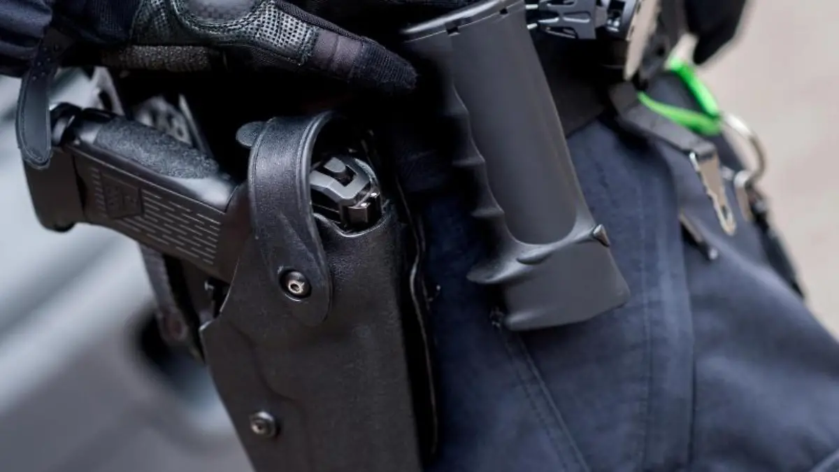 Ein Beamter trägt die Dienstwaffe am Gürtel. Foto: Hauke-Christian Dittrich/dpa/Symbolbild
