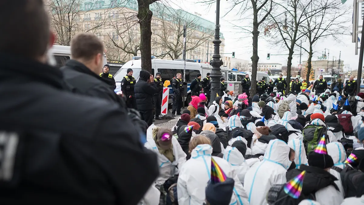 Demonstranten der Letzten Generation haben versucht, mit Sitzblockaden Zugänge zu dem weiträumig abgesperrten Hotel Adlo in Berlin zu blockieren. Polizisten zogen, drängten und trugen sie weg.
