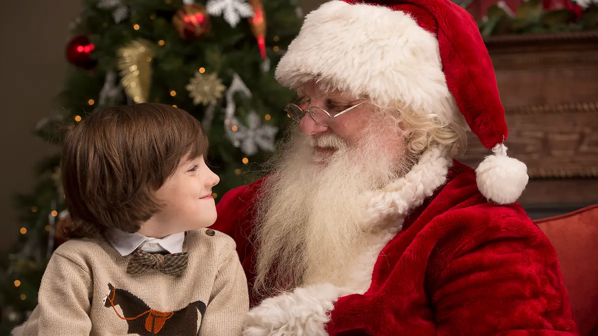 Ein Junge sitzt auf dem Schoß vom Nikolaus / dem Weihnachtsmann.