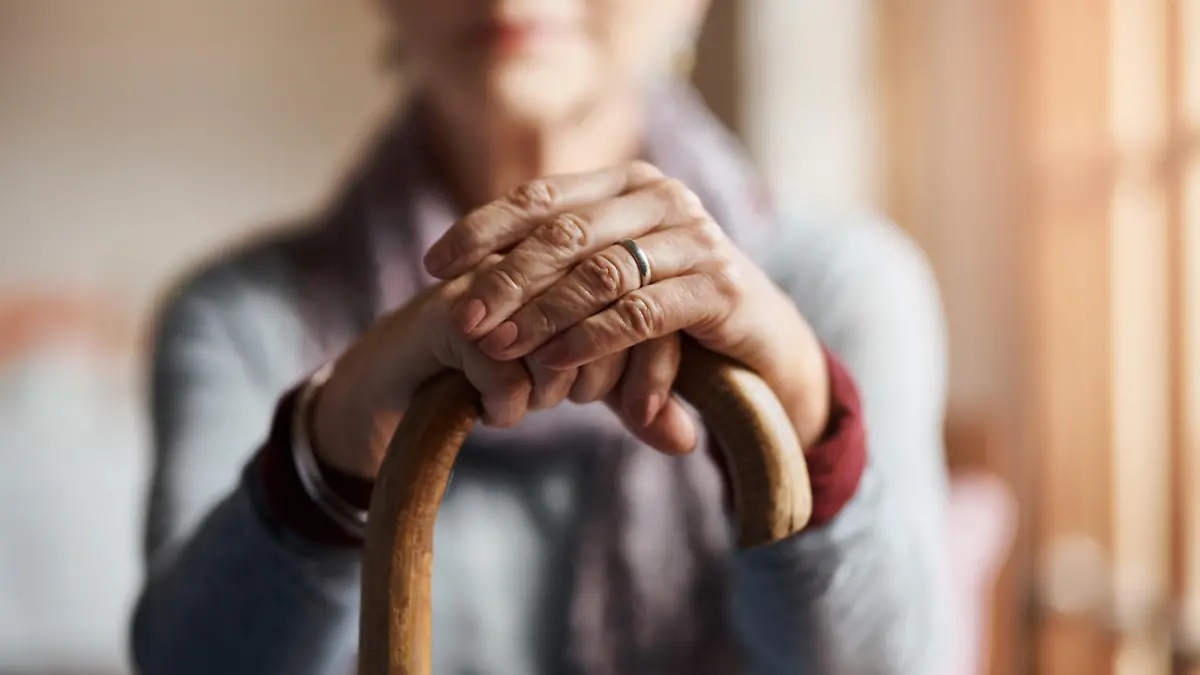 Cropped shot of a senior woman holding a cane in a retirement home