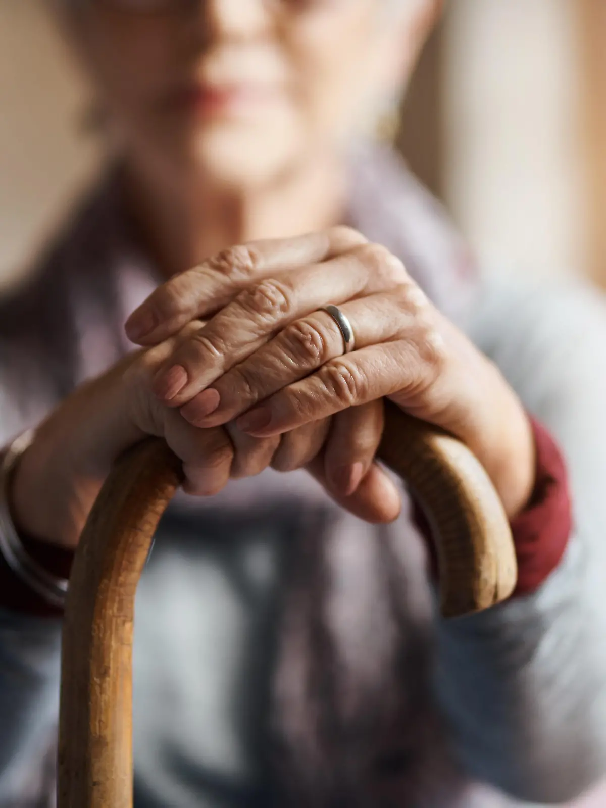 Cropped shot of a senior woman holding a cane in a retirement home