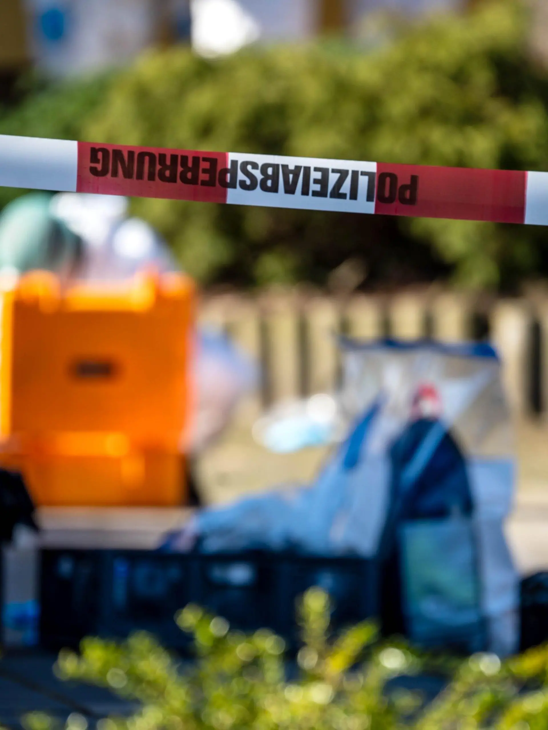 28.02.2023, Niedersachsen, Bramsche: Ein Flatterband der Polizei hängt am Tatort. Nach den Schüssen vor einer Schule in Bramsche bei Osnabrück ist ein 16-Jähriger laut Staatsanwaltschaft an seinen schweren Verletzungen gestorben. Der Jugendliche war am Dienstagmorgen in Bramsche von einem 81-Jährigen durch Schüsse lebensgefährlich verletzt worden. (zu dpa 16-Jähriger nach Schüssen in Bramsche gestorben) Foto: Sina Schuldt/dpa +++ dpa-Bildfunk +++