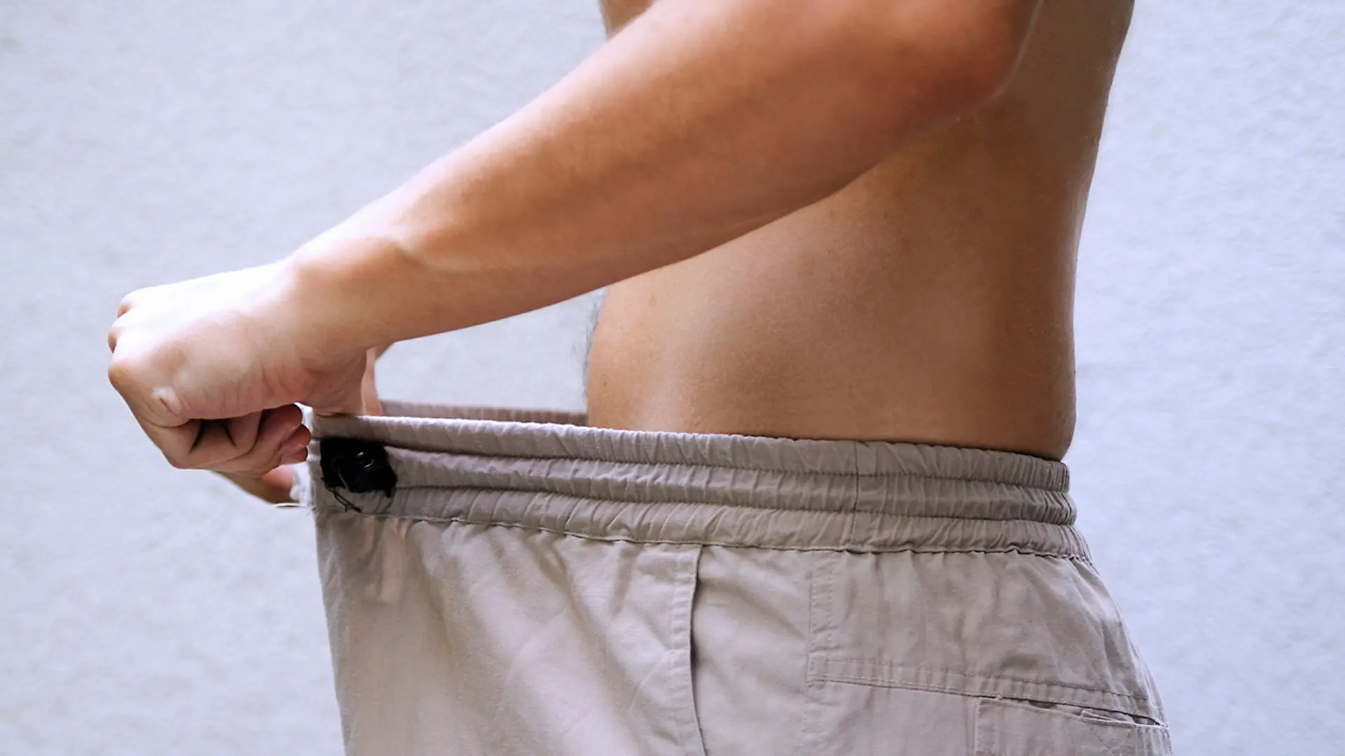 Ein Mann in Unterhose schaut sich in seinen Intimbereich.