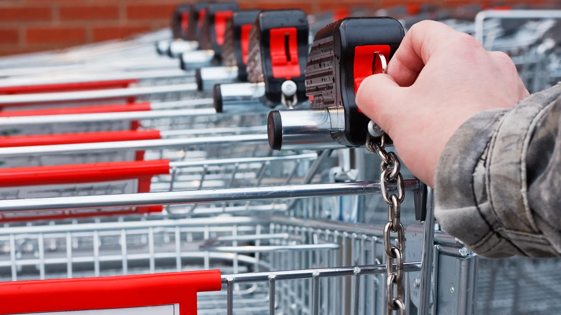 Inserting coin or token into shopping cart at the superstore