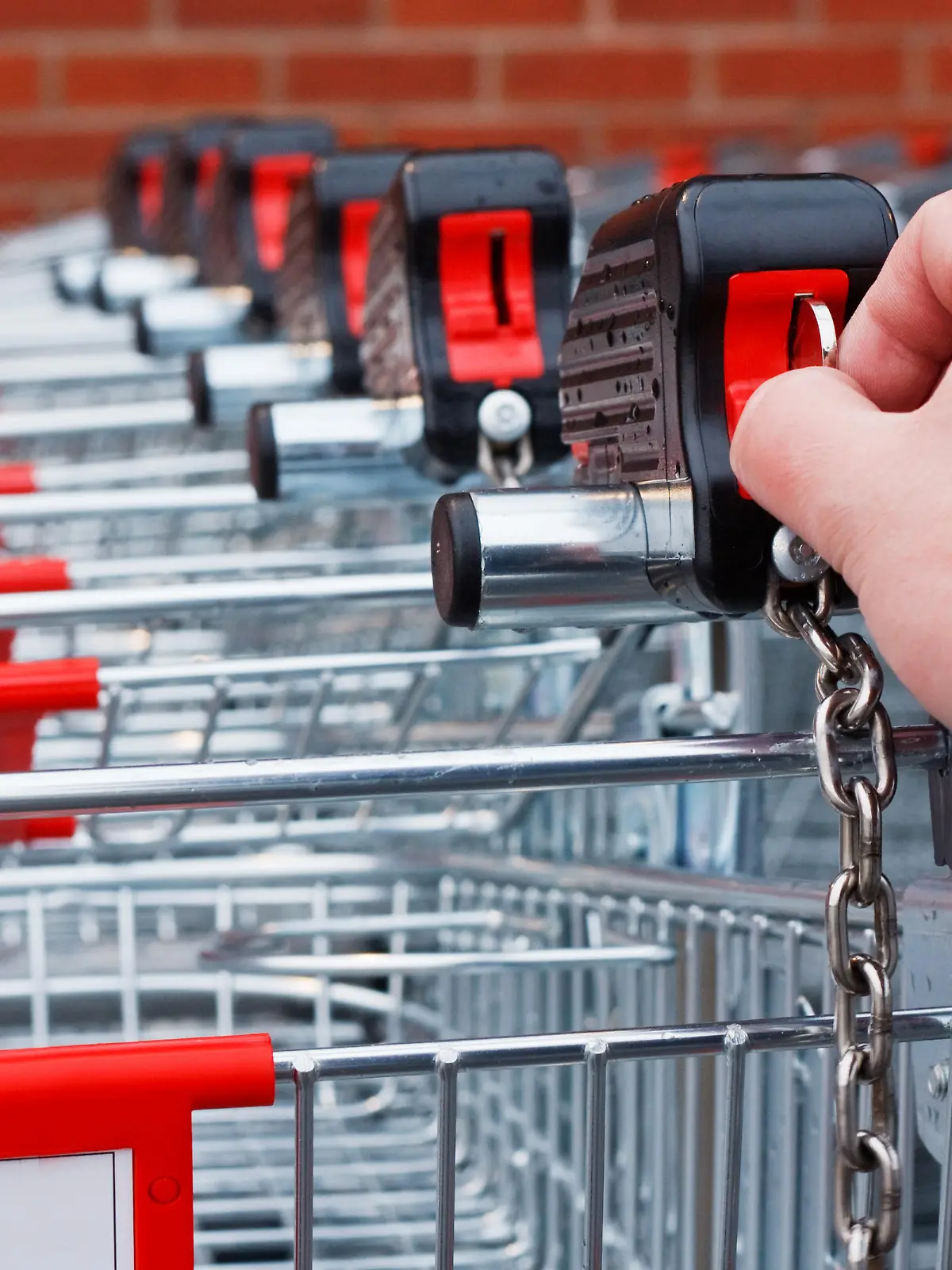 Inserting coin or token into shopping cart at the superstore