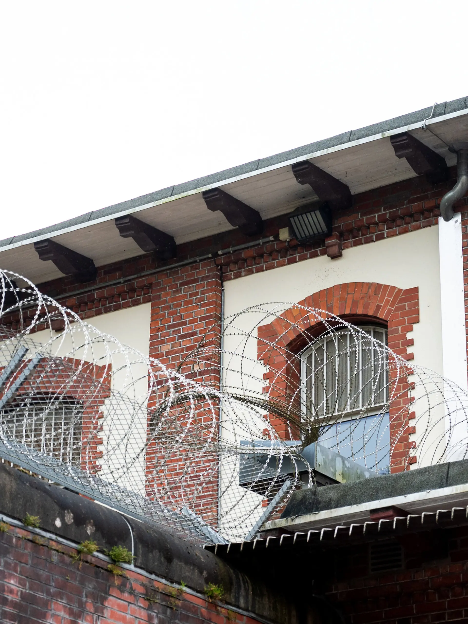 ARCHIV - 10.05.2023, Hamburg: Stacheldraht und vergitterte Fenster sichern den forensischen Teil (geschlossene Unterbringung) der psychiatrischen Klinik der Hamburger Asklepios-Klinik Nord / Ochsenzoll. 130 Jahre nach ihrer Gründung stellt die starke Zunahme der psychiatrischen Erkrankungen die Klinik vor große Herausforderungen. (zu dpa: «Suche nach aus Entziehungsanstalt geflohenem Mann dauert an») Foto: Daniel Bockwoldt/dpa +++ dpa-Bildfunk +++