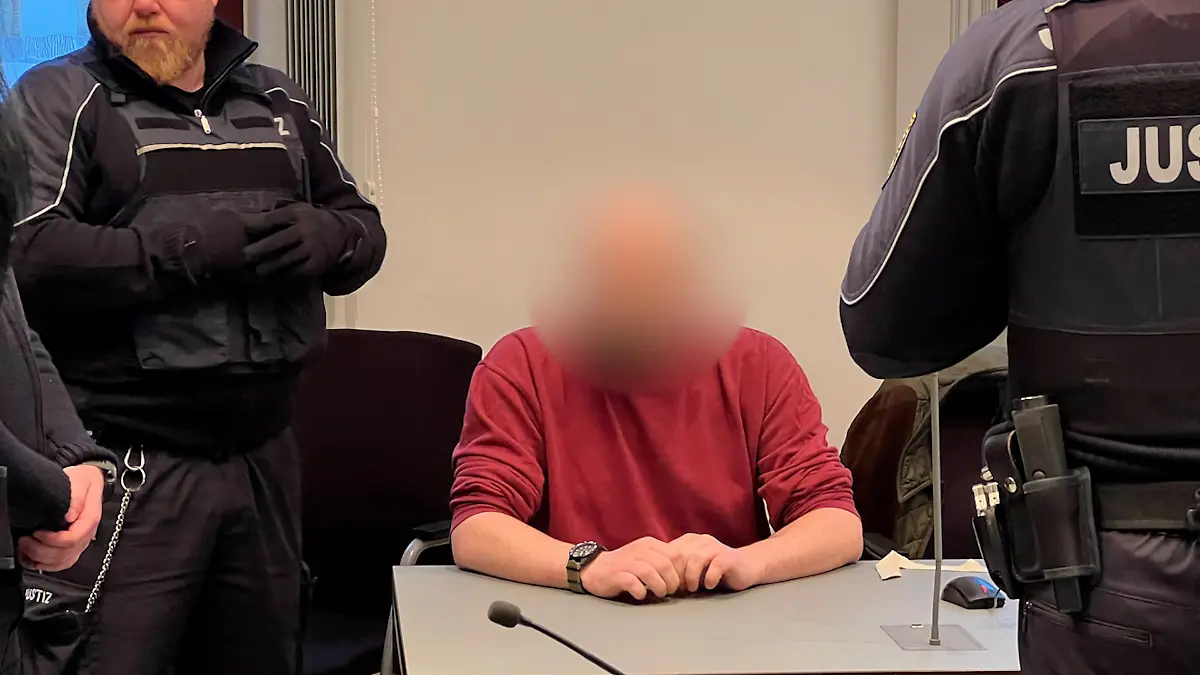 Mit Handschellen, Fußfesseln und vier Justizbeamten wird der Mann in den Gerichtsaal geführt.