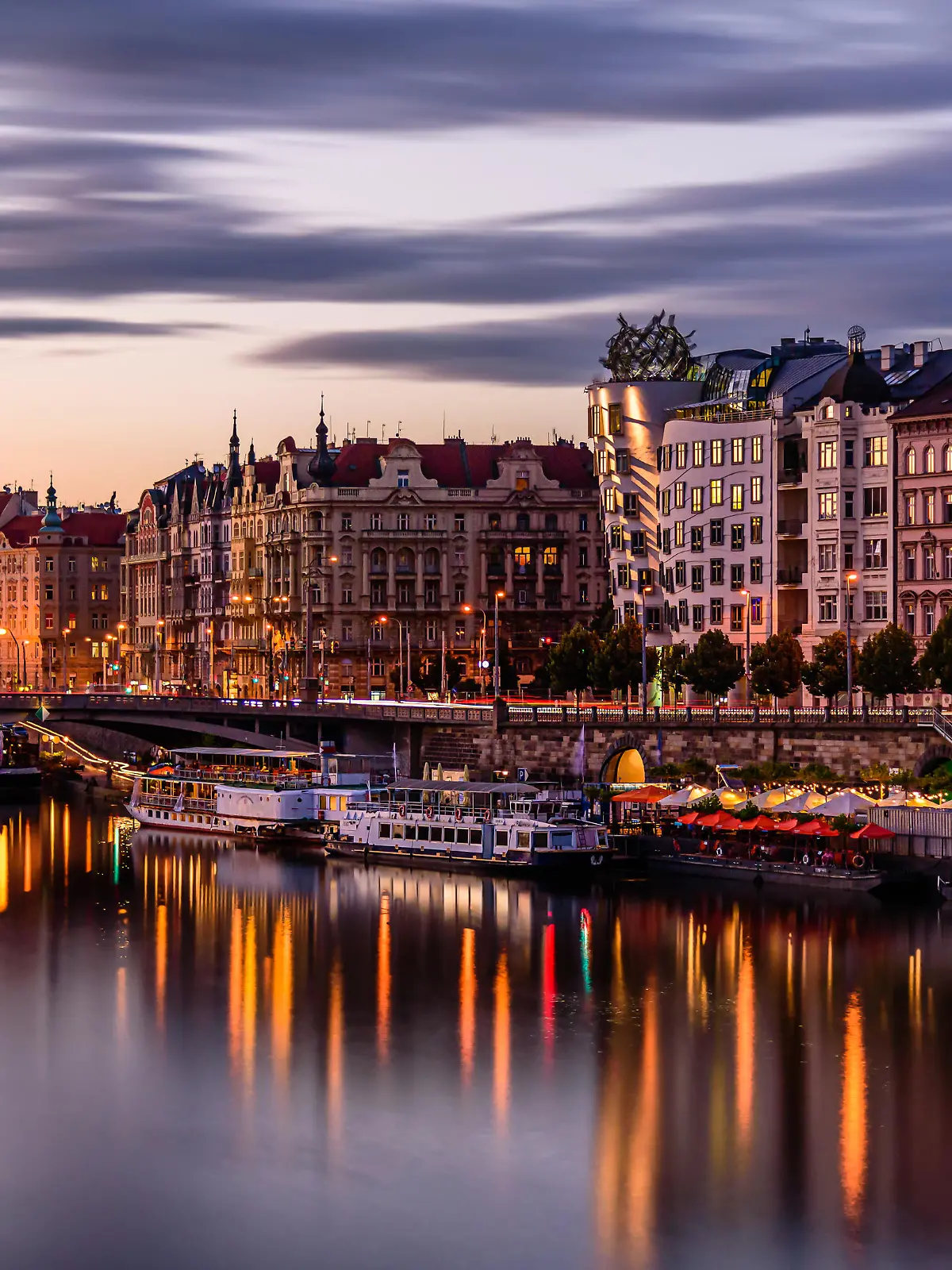 Prague's waterside by the Vltava river called Prazska naplavka in twilight.