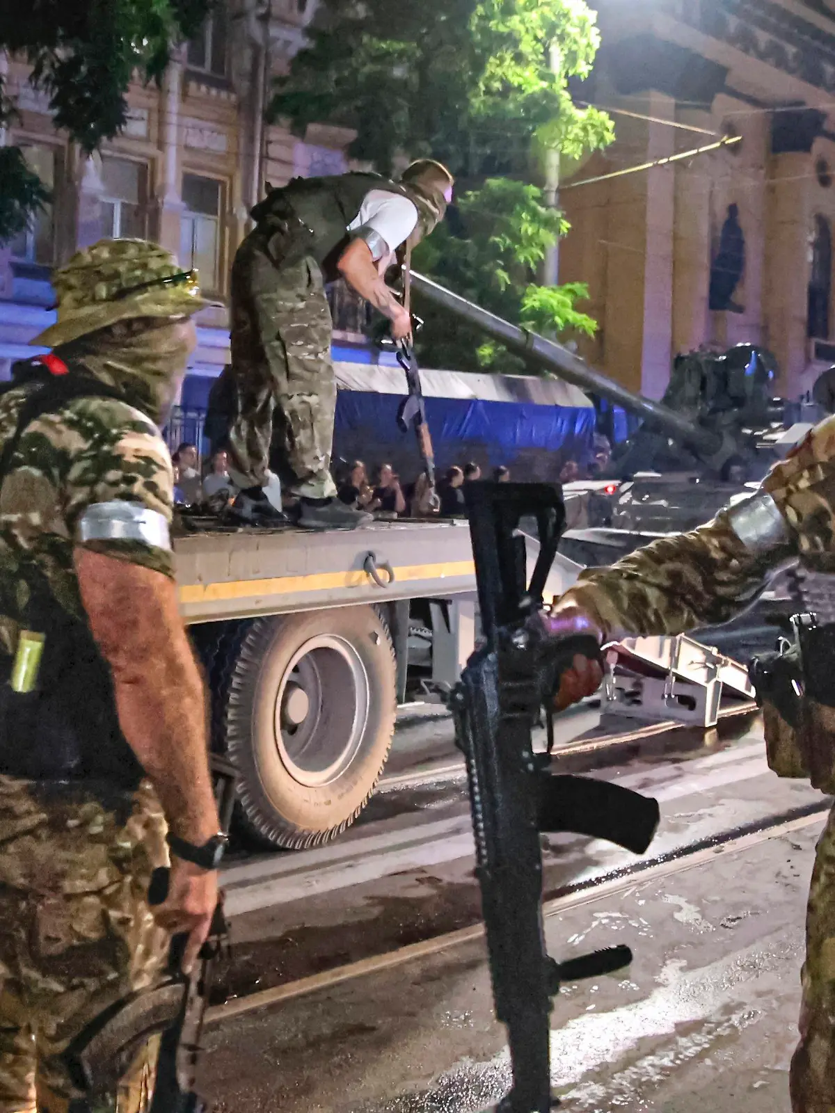 24.06.2023, Russland, Rostow am Don: Mitglieder des Söldnergruppe Wagner bewachen einen Bereich, während andere ihren Panzer auf einen Lastwagen auf einer Straße in Rostow am Don laden, bevor sie einen Bereich im Hauptquartier des südlichen Militärbezirks verlassen. Der bewaffnete Aufstand russischer Söldner gegen die eigene Staatsführung ist beendet. Nur wenige Stunden nach Beginn des Vormarschs gen Moskau erteilte Söldnerchef Prigoschin am Samstagabend (24.06.2023) den Befehl zum Rückzug seiner Privatarmee. Foto: Vasily Deryugin/Kommersant Publishing House/AP/dpa +++ dpa-Bildfunk +++