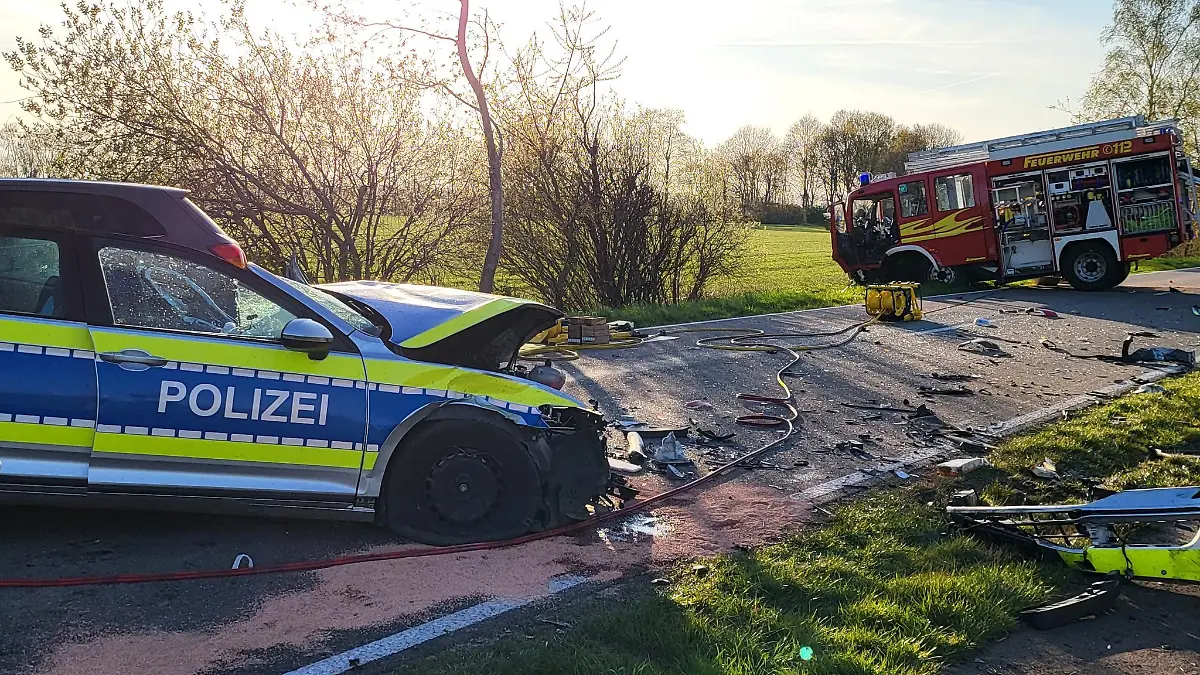 19.04.2022, Niedersachsen, Hoogstede: Ein beschädigtes Polizeiauto und ein Einsatzfahrzeug der Feuerwehr stehen am Unfallort. Bei einem Frontalzusammenstoß zwischen Polizei und Feuerwehr bei Hoogstede im Landkreis Grafschaft Bentheim auf dem Weg zu einem Brand sind zwei Polizisten verletzt worden. Foto: ---/Nord-West-Media TV /dpa +++ dpa-Bildfunk +++
