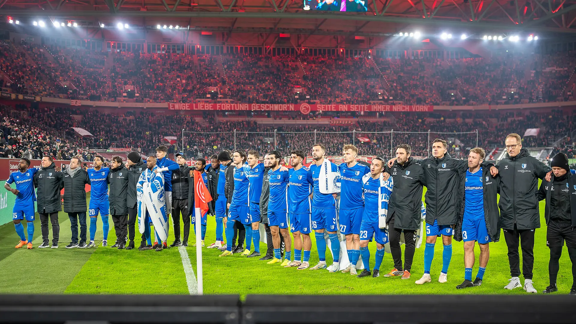 Die Mannschaft des FC Magdeburg versammelt sich nach dem Spiel gegen Fortuna Düsseldorf schweigend vor ihren Fans.