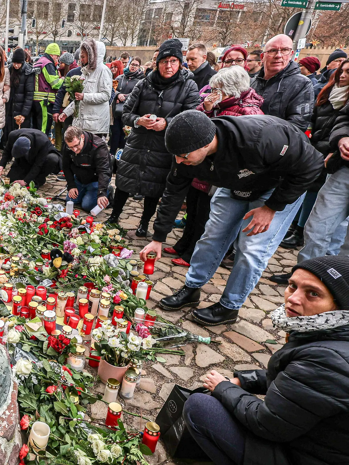Der Magdeburger Weihnachtsmarkt am Tag nach dem Anschlag. Menschen legen Blumen nieder. Sie trauern um die mindestens fünf Toten und mehr als 200 Verletzen.