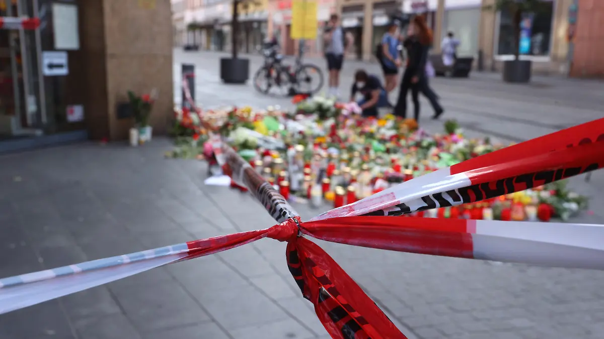 ARCHIV - 27.06.2021, Bayern, Würzburg: Blumen und Kerzen vor einem abgesperrten Kaufhaus, in dem ein Mann Menschen mit einem Messer attackiert hatte. (zu dpa "«Da war viel Blut» - Messerstecher von Würzburg vor Gericht") Foto: Karl-Josef Hildenbrand/dpa +++ dpa-Bildfunk +++