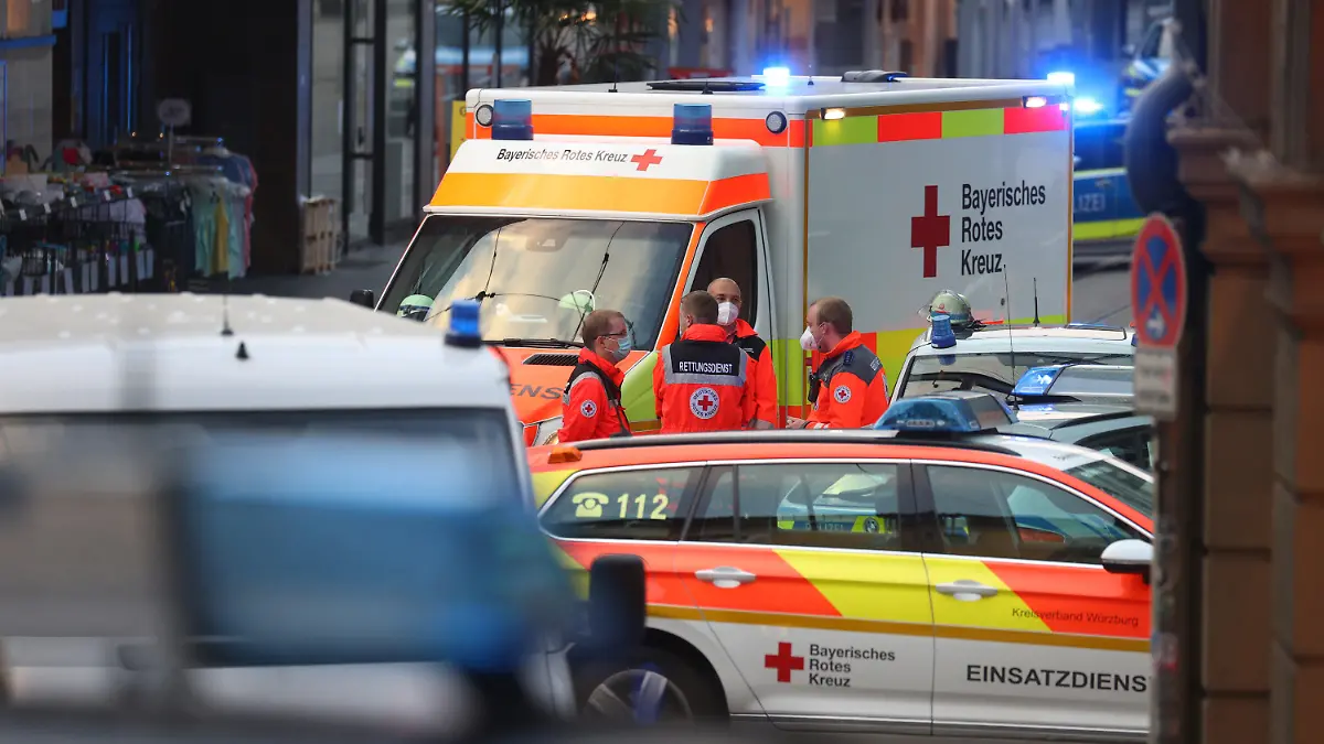 25.06.2021, Bayern, Würzburg: Rettungskräfte stehen in der Innenstadt. In Würzburg hat ein Mann wahllos Menschen mit einem Messer attackiert. Nach Informationen der Deutschen Presse-Agentur sind drei Personen getötet und fünf verletzt worden. Foto: Karl-Josef Hildenbrand/dpa +++ dpa-Bildfunk +++