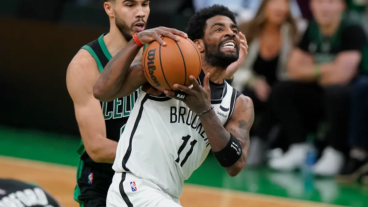 Brooklyn Nets guard Kyrie Irving (11) drives toward the basket as Boston Celtics forward Jayson Tatum (0) defends in the second half of Game 1 of an NBA basketball first-round Eastern Conference playoff series, Sunday, April 17, 2022, in Boston. The Celtics won 115-114. (AP Photo/Steven Senne)