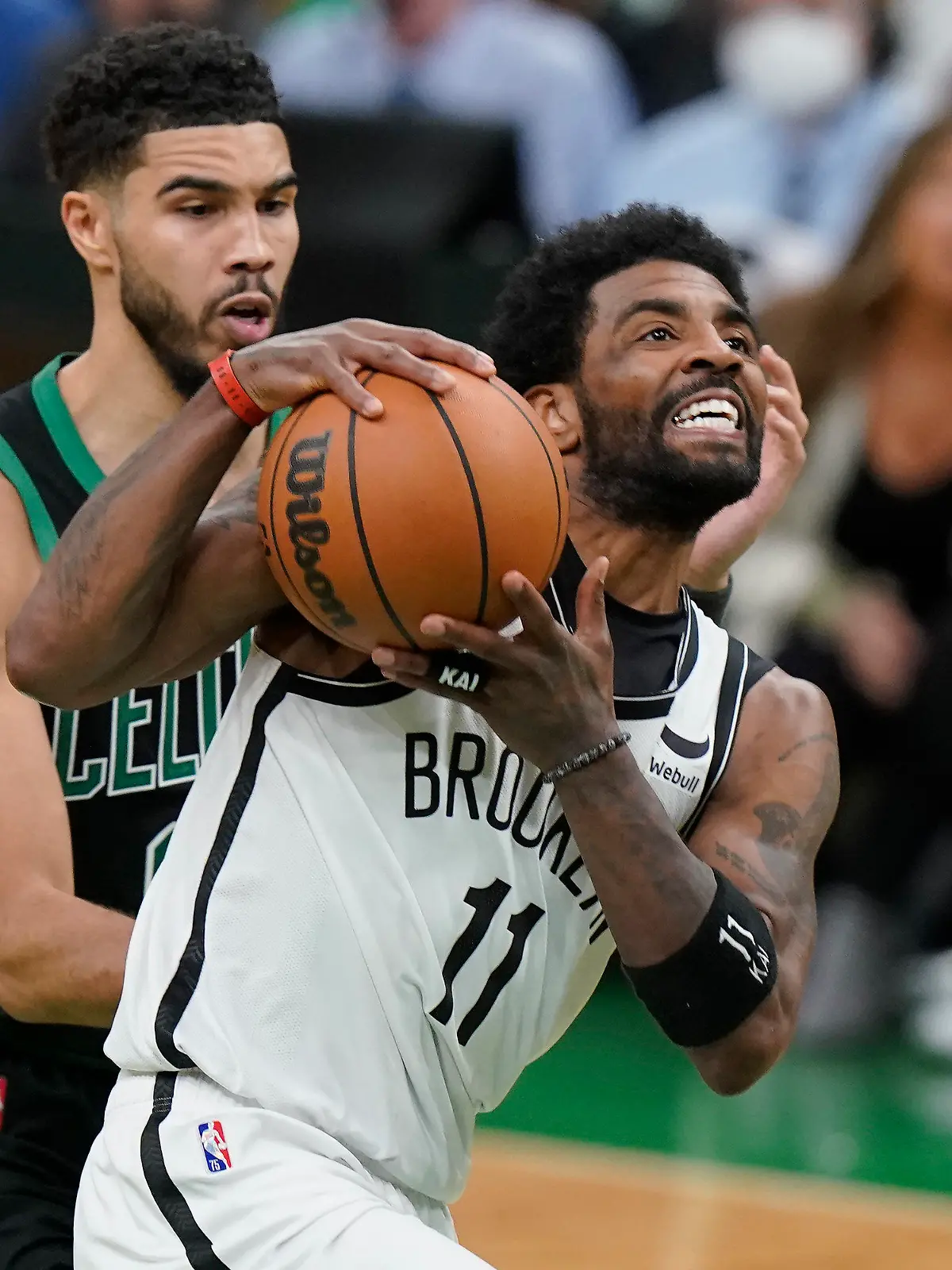Brooklyn Nets guard Kyrie Irving (11) drives toward the basket as Boston Celtics forward Jayson Tatum (0) defends in the second half of Game 1 of an NBA basketball first-round Eastern Conference playoff series, Sunday, April 17, 2022, in Boston. The Celtics won 115-114. (AP Photo/Steven Senne)