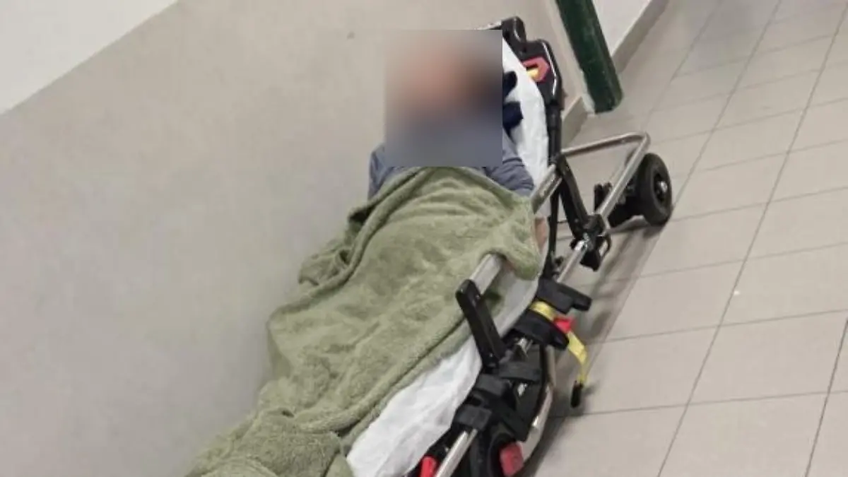 Eine Frau auf einer Krankenbahre in einer Notaufnahme. 