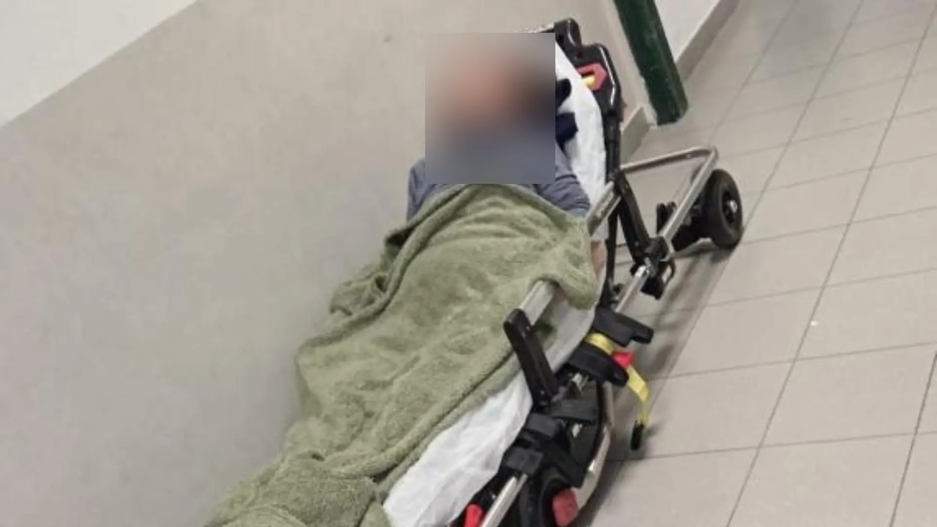 Eine Frau auf einer Krankenbahre in einer Notaufnahme. 