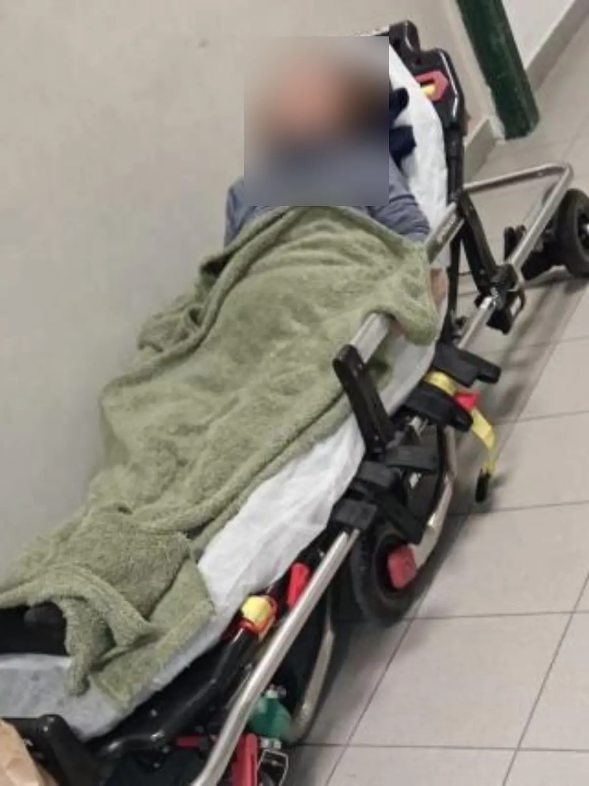 Eine Frau auf einer Krankenbahre in einer Notaufnahme. 