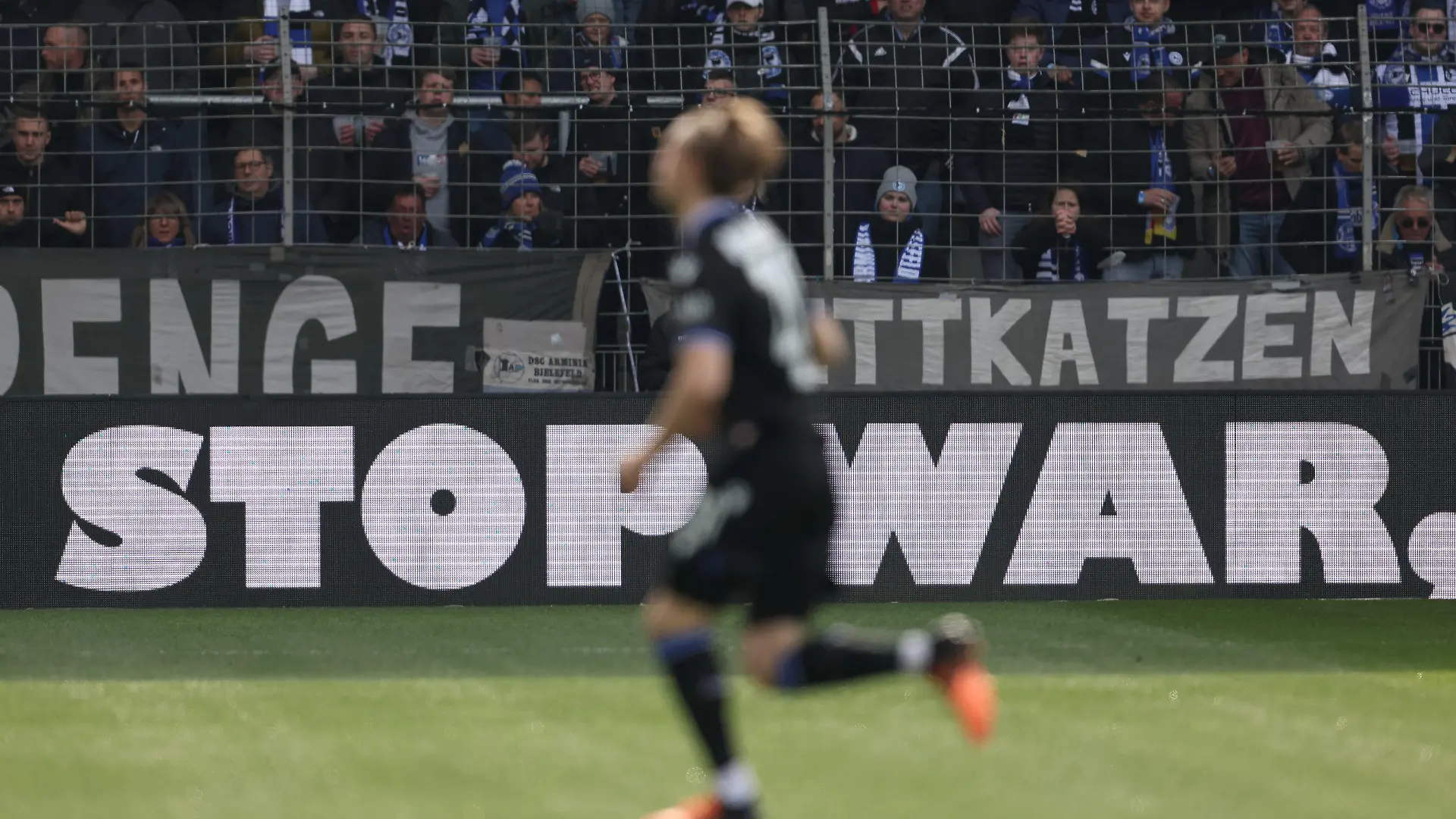 02.04.2022, Nordrhein-Westfalen, Bielefeld: Fußball: Bundesliga, Arminia Bielefeld - VfB Stuttgart, 28. Spieltag in der Schüco-Arena. "Stop War" steht auf einer Werbebande. Foto: Friso Gentsch/dpa - WICHTIGER HINWEIS: Gemäß den Vorgaben der DFL Deutsche Fußball Liga bzw. des DFB Deutscher Fußball-Bund ist es untersagt, in dem Stadion und/oder vom Spiel angefertigte Fotoaufnahmen in Form von Sequenzbildern und/oder videoähnlichen Fotostrecken zu verwerten bzw. verwerten zu lassen. +++ dpa-Bildfunk +++