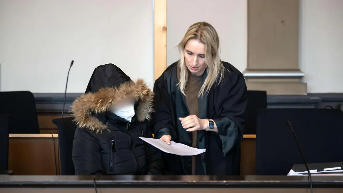 21.02.2023, Niedersachsen, Verden: Die Angeklagte spricht vor Prozessbeginn mit ihrer Anwältin Daniela Post (r). Wegen des Todes ihres vierjährigen Kindes muss sich eine Mutter vor dem Landgericht Verden verantworten. Die Staatsanwaltschaft wirft der 25-Jährigen vor, im August vorigen Jahres in Grasberg (Landkreis Osterholz) das Kind zur Bestrafung mit mindestens 55 Grad heißem Wasser übergossen zu haben. Foto: Sina Schuldt/dpa - ACHTUNG: Person(en) wurde(n) aus rechtlichen Gründen gepixelt +++ dpa-Bildfunk +++