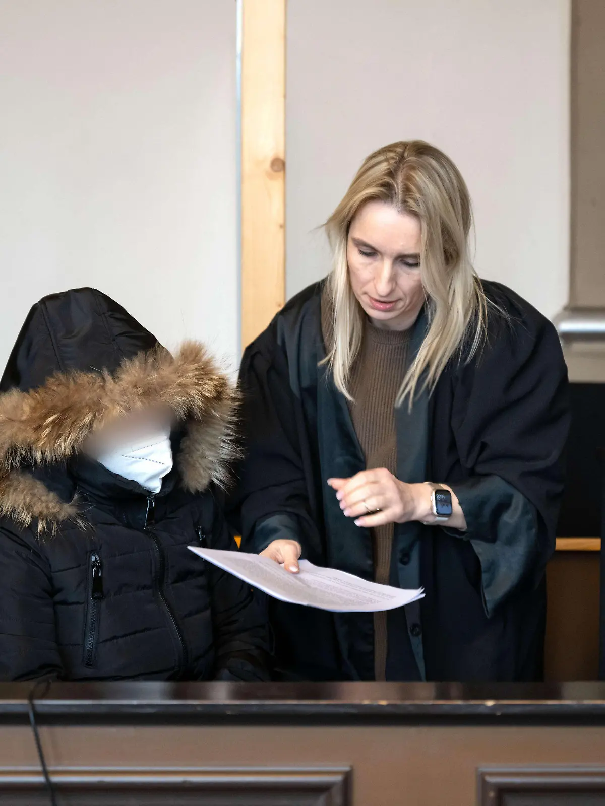 21.02.2023, Niedersachsen, Verden: Die Angeklagte spricht vor Prozessbeginn mit ihrer Anwältin Daniela Post (r). Wegen des Todes ihres vierjährigen Kindes muss sich eine Mutter vor dem Landgericht Verden verantworten. Die Staatsanwaltschaft wirft der 25-Jährigen vor, im August vorigen Jahres in Grasberg (Landkreis Osterholz) das Kind zur Bestrafung mit mindestens 55 Grad heißem Wasser übergossen zu haben. Foto: Sina Schuldt/dpa - ACHTUNG: Person(en) wurde(n) aus rechtlichen Gründen gepixelt +++ dpa-Bildfunk +++