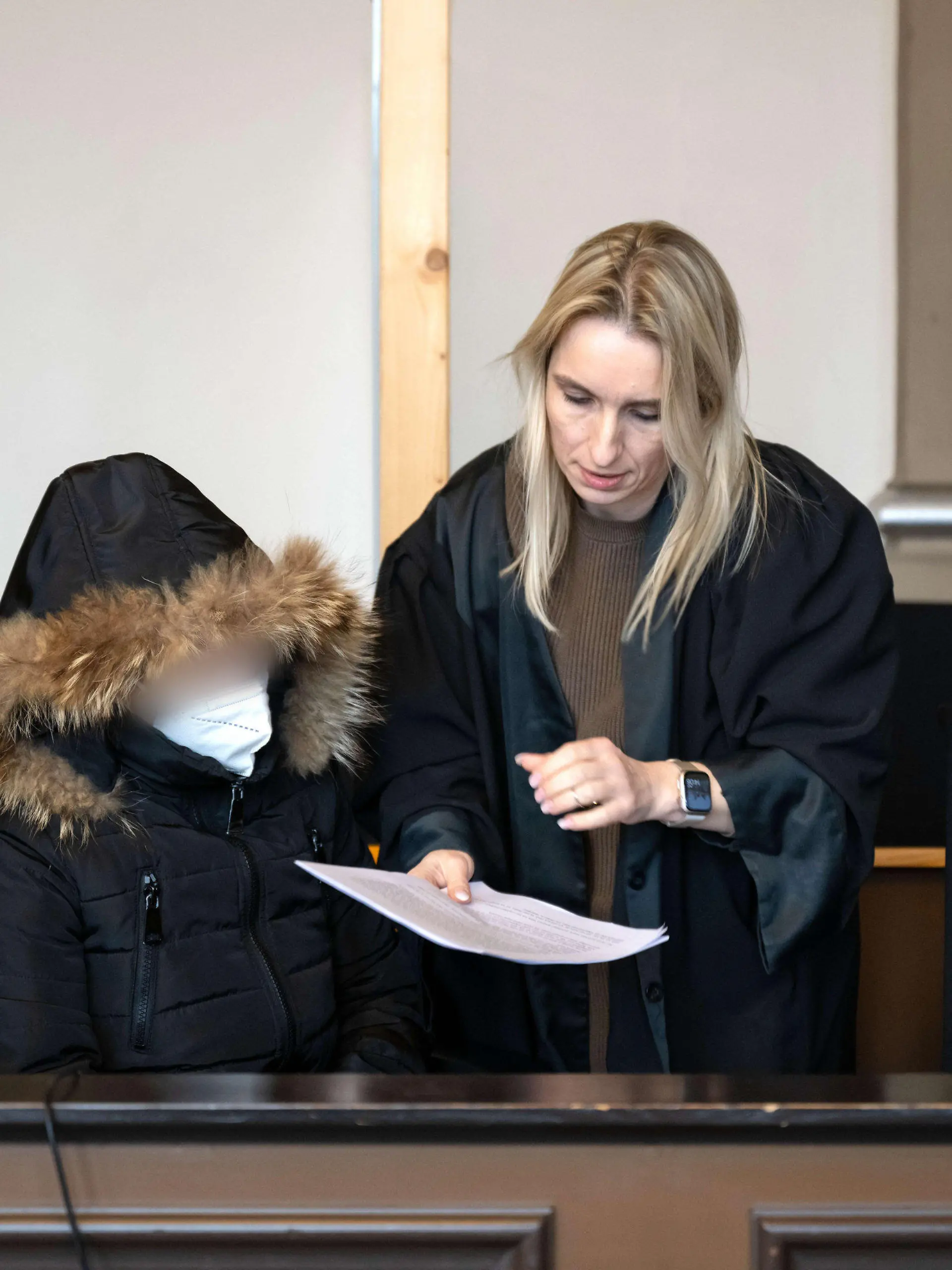 21.02.2023, Niedersachsen, Verden: Die Angeklagte spricht vor Prozessbeginn mit ihrer Anwältin Daniela Post (r). Wegen des Todes ihres vierjährigen Kindes muss sich eine Mutter vor dem Landgericht Verden verantworten. Die Staatsanwaltschaft wirft der 25-Jährigen vor, im August vorigen Jahres in Grasberg (Landkreis Osterholz) das Kind zur Bestrafung mit mindestens 55 Grad heißem Wasser übergossen zu haben. Foto: Sina Schuldt/dpa - ACHTUNG: Person(en) wurde(n) aus rechtlichen Gründen gepixelt +++ dpa-Bildfunk +++