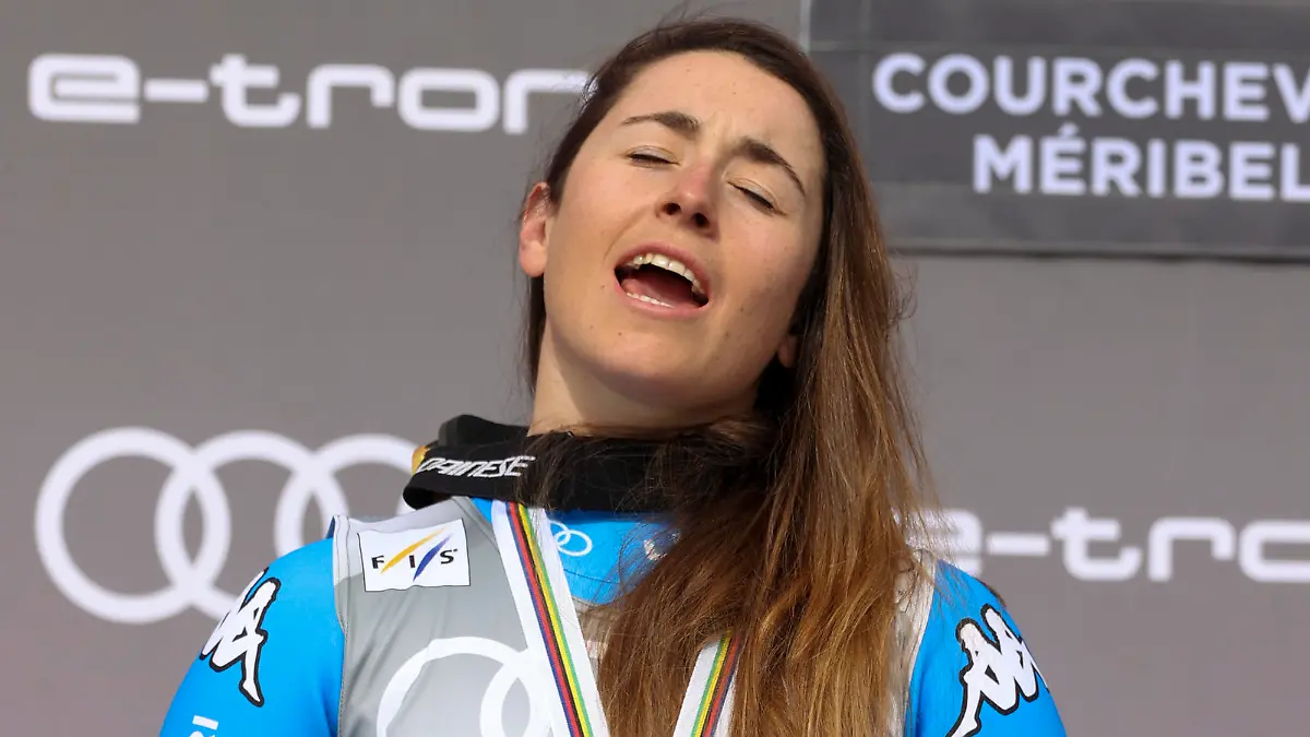 Italy's Sofia Goggia celebrates with the women's downhill overall leader cup, on the podium of an alpine ski, women's World Cup Finals downhill, in Courchevel, France, Wednesday, March 16, 2022. (AP Photo/Alessandro Trovati)