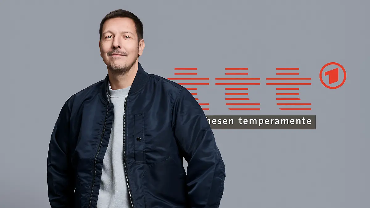 Der neue Moderator der ARD-Sendung „ttt”, Thilo Mischke, steht vor einem Logo der Sendung.