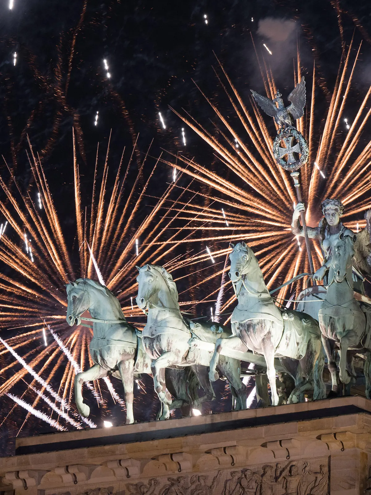 ARCHIV - 01.01.2024, Berlin: Feuerwerk zum Jahreswechsel steigt während der Feier «Silvester am Brandenburger Tor» hinter dem Brandenburger Tor auf. (zu dpa: «Silvesterparty in Mitte - Aufbauarbeiten beginnen») Foto: Sebastian Gollnow/dpa +++ dpa-Bildfunk +++