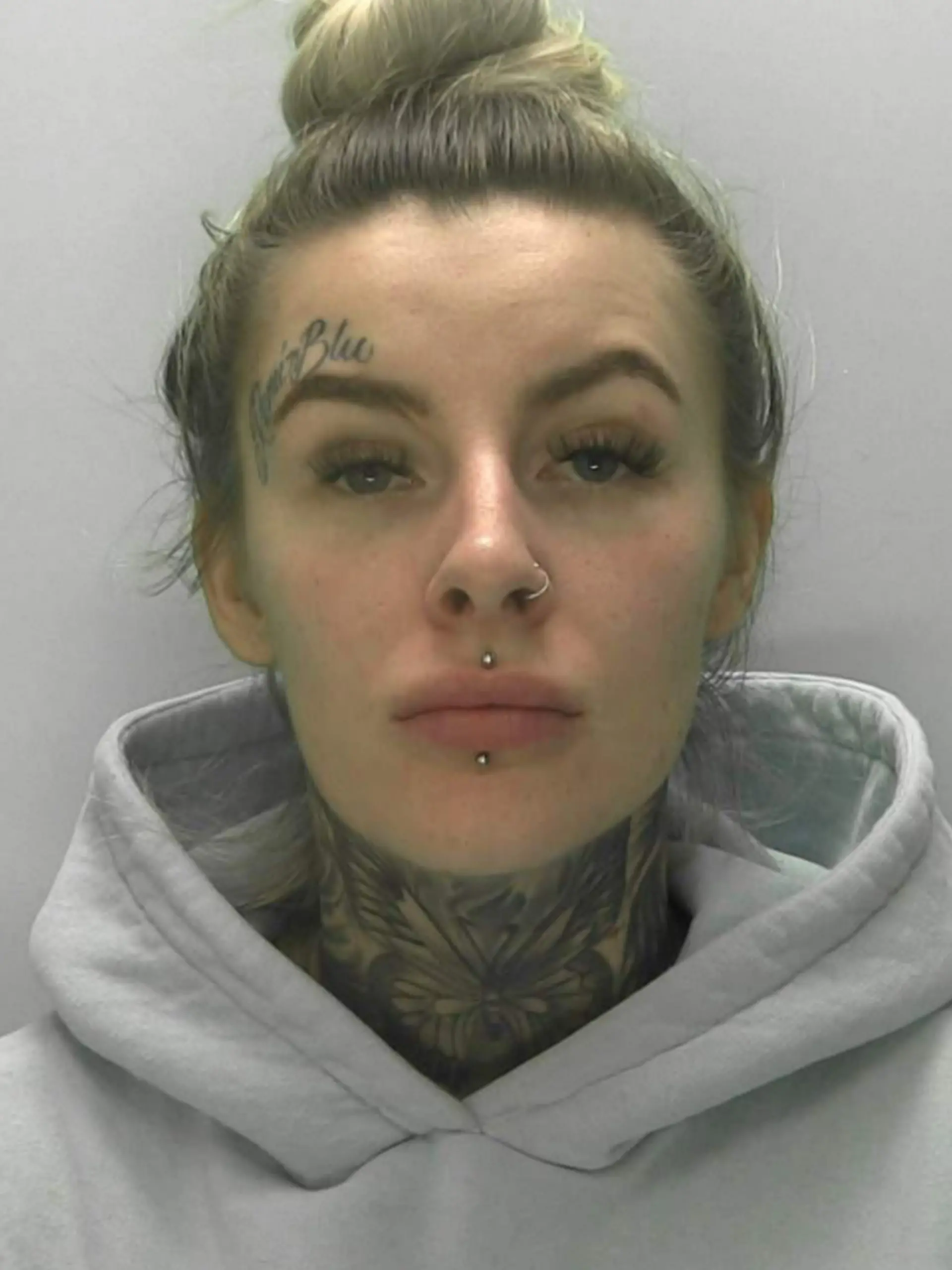 Eine Frau mit blonden Haaren und Gesichtstattoos.