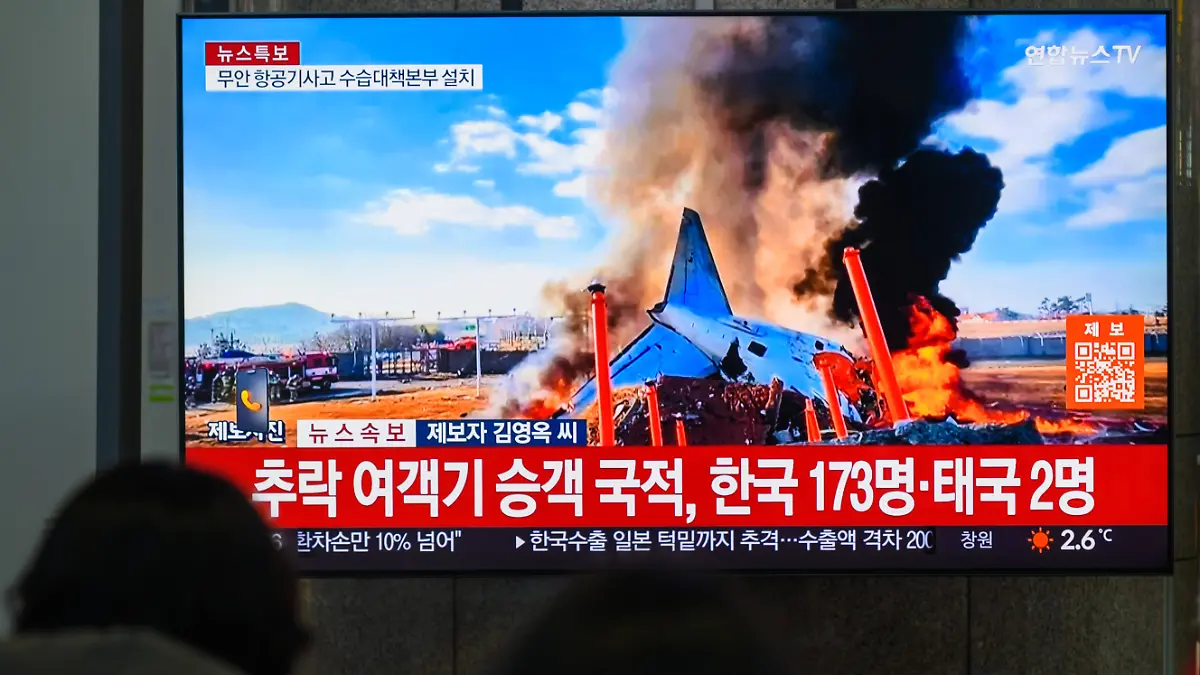 Bildschirm mit Aufnahmen des Flugzeugunglücks in Südkorea