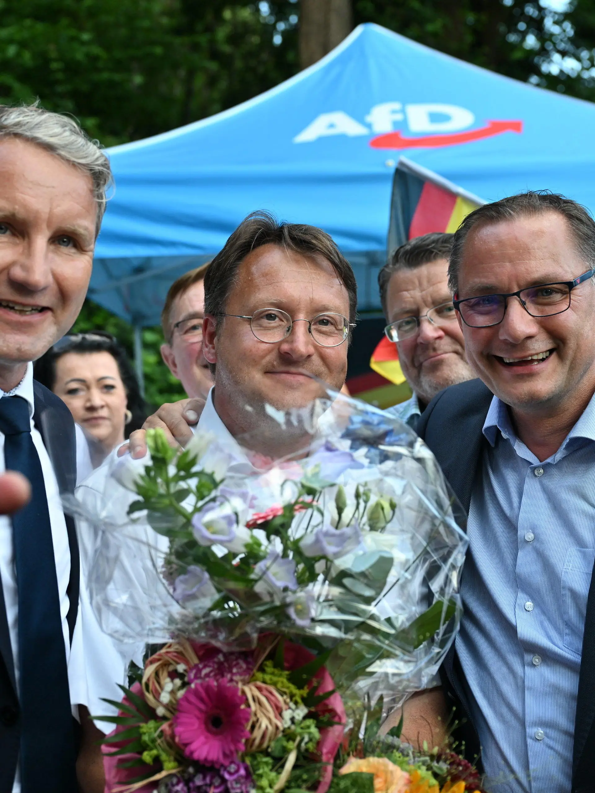 25.06.2023, Thüringen, Sonneberg: Björn Höcke, Vorsitzender der AfD Thüringen (l) und Tino Chrupalla, AfD-Bundesvorsitzender (r) gratulieren im Garten des Restaurants Frankenbaude dem Wahlsieger des Thüringer Kreis Sonneberg, Robert Sesselmann (AfD,M). Der ehemalige Landrat Hans-Peter Schmitz (parteilos) war aufgrund einer langwierigen Erkrankung in den Ruhestand versetzt worden. Der AfD-Abgeordnete Robert Sesselmann hatte in der ersten Runde die meisten Stimmen erhalten. Er wäre der erste AfD-Landrat in Deutschland. In der Stichwahl tritt er gegen Jürgen Köpper (CDU) an. Foto: Martin Schutt/dpa +++ dpa-Bildfunk +++