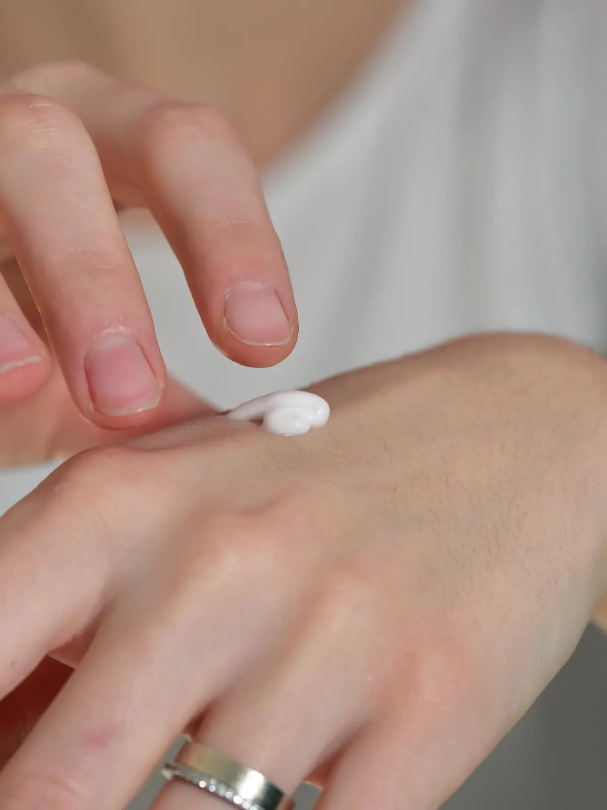 Frau trägt Handcreme auf. 