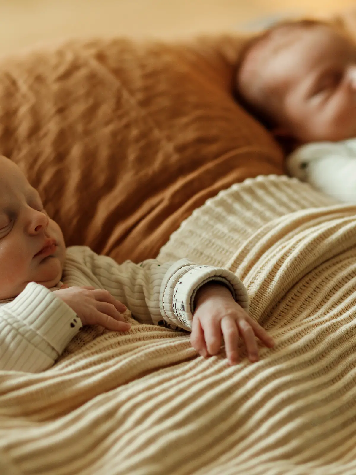 Zwillingsbabys liegen nebeneinander im Bett.