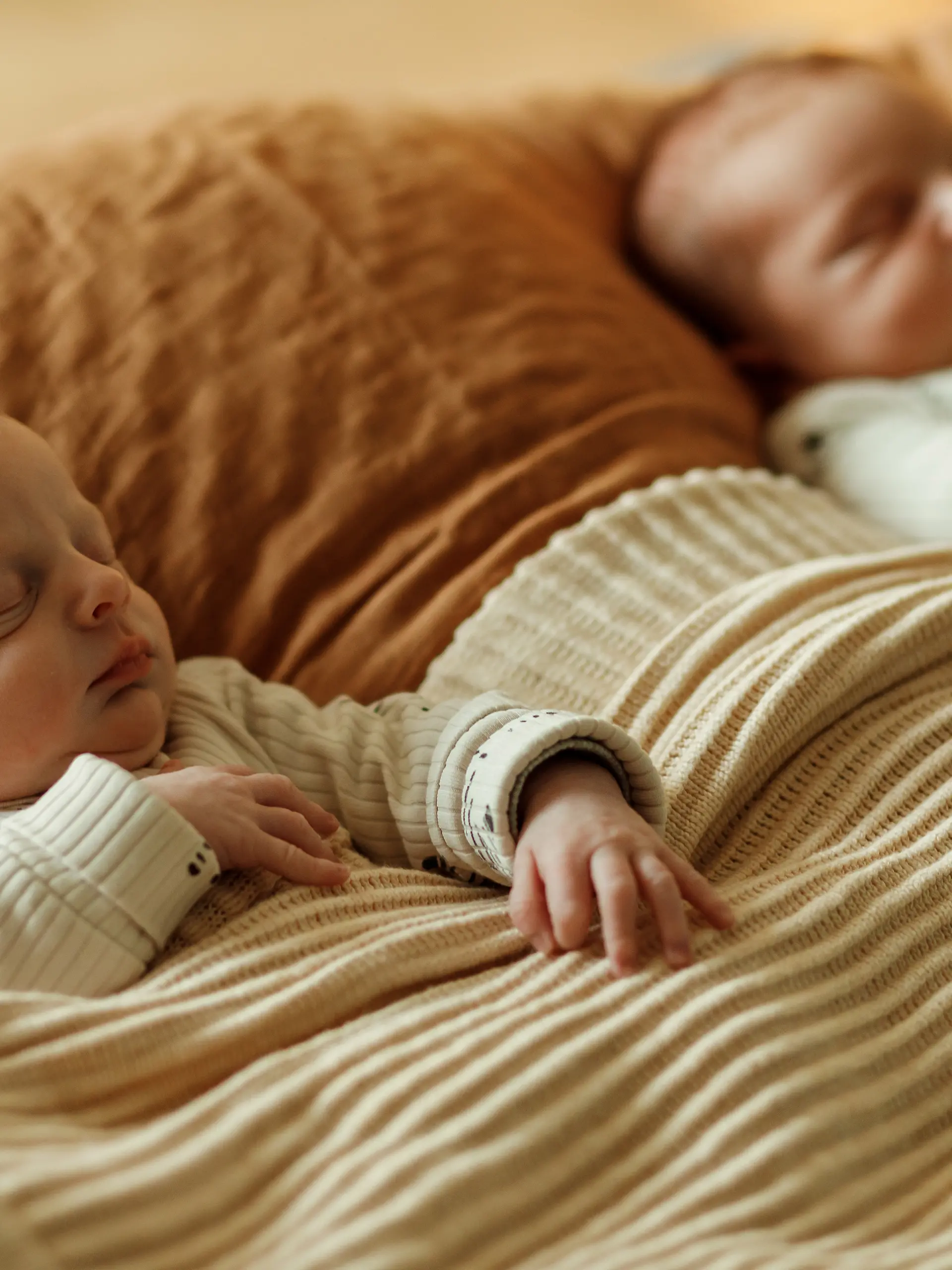 Zwillingsbabys liegen nebeneinander im Bett.