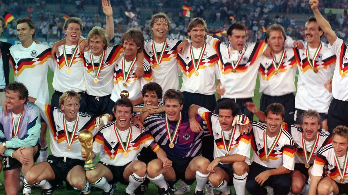 ARCHIV - Die deutsche Mannschaft stellt sich nach dem 1:0-Finalsieg gegen Argentinien bei der Fußball-Weltmeisterschaft am 08.07.1990 im Olympiastadion von Rom zum Mannschaftsfoto auf: Stehend (v.l.): Klaus Augenthaler, Stefan Reuter, Jürgen Klinsmann, Frank Mill, Guido Buchwald, Paul Steiner, Thomas Berthold, Andreas Köpke, Jürgen Kohler; Hockend (v.l.): Torwart-Trainer Sepp Maier, Andreas Brehme, Lothar Matthäus (mit dem WM-Pokal), Karlheinz Riedle, Bodo Illgner, Uwe Bein, Günter Hermann, Rudi Völler, Thomas Häßler. Foto: Frank Leonhardt/dpa (zu dpa Hintergrund "Das machen die Fußball-Weltmeister von 1990 heute" am 06.07.2015) +++(c) dpa - Bildfunk+++