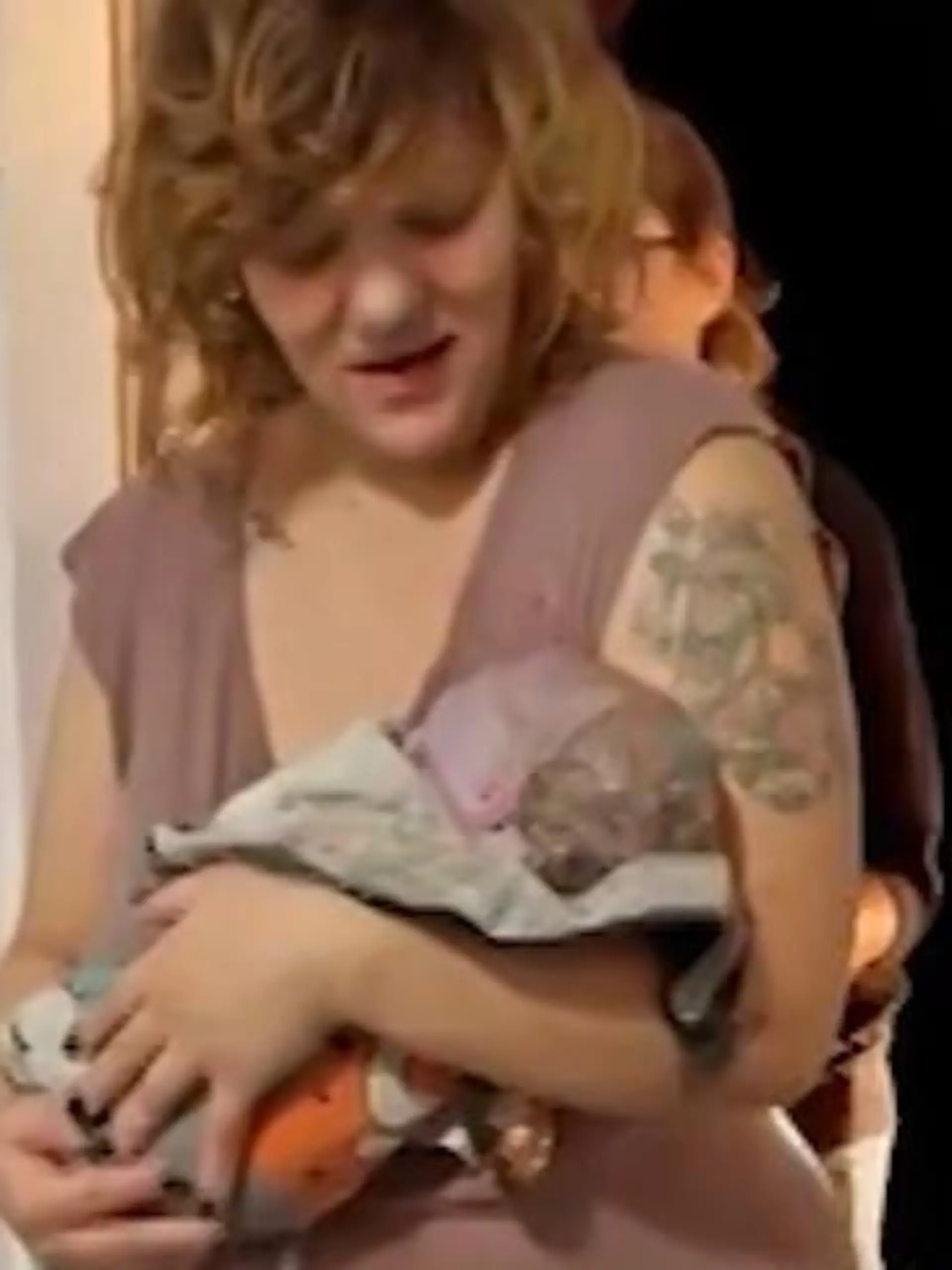 Samantha kommt mit ihrem Baby auf dem Arm in eine Wohnung.