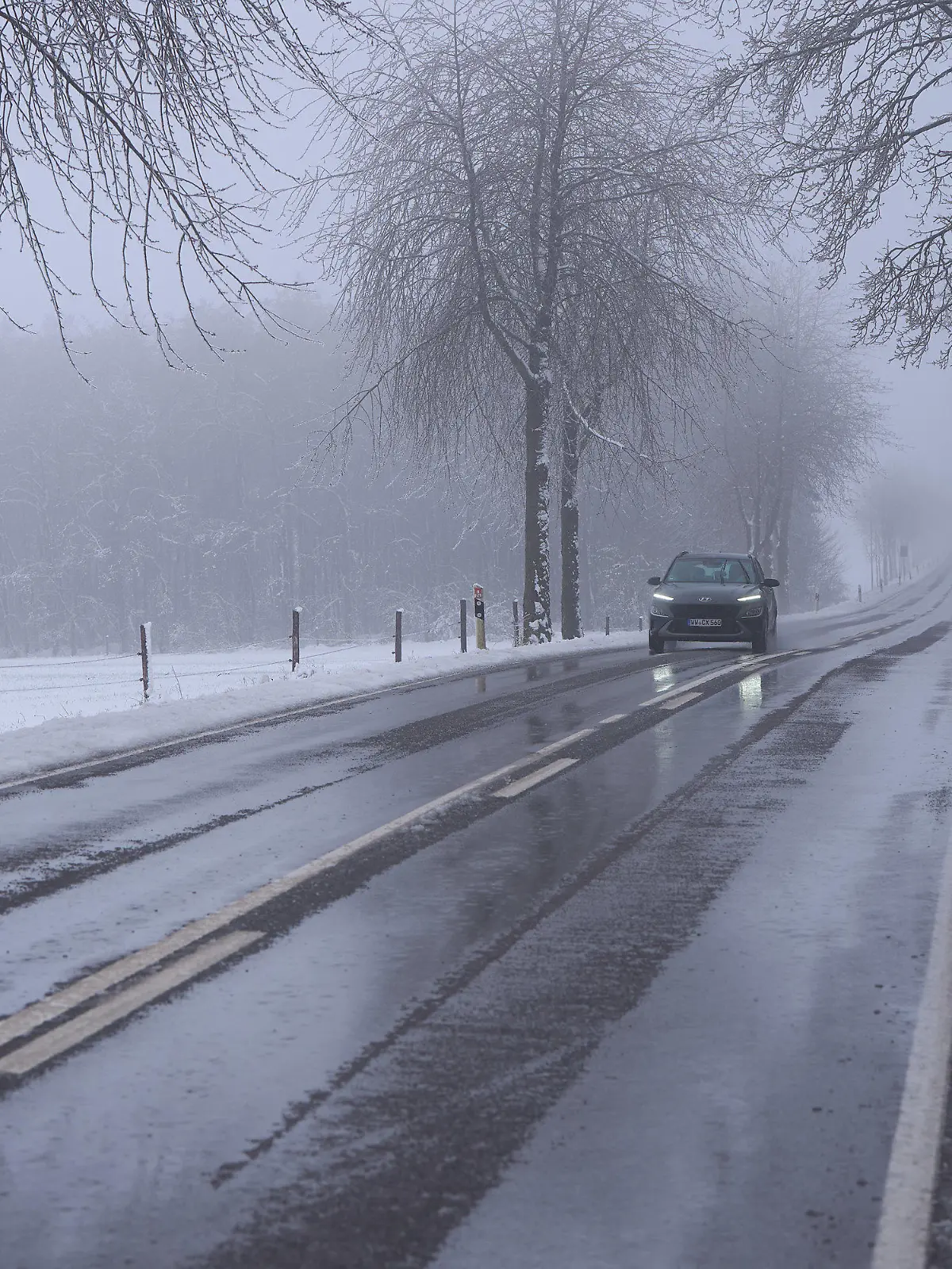 05.01.2025, Rheinland-Pfalz, Stockum-Püschen: Regenwasser steht auf einer Landstraße bei Stockum-Püschen im Westerwald. Auf den Schnee folgt Regen. Foto: Thomas Frey/dpa +++ dpa-Bildfunk +++