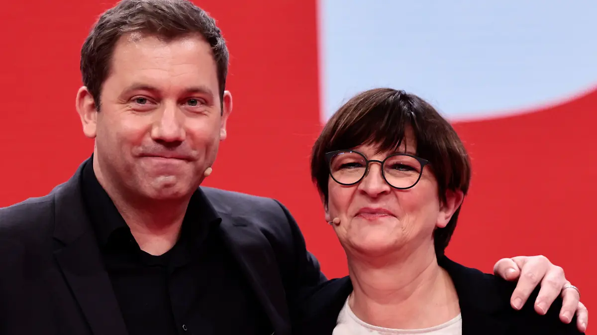 New-elected SPD co-leader Lars Klingbeil, left, poses with re-elected SPD co-leader Saskia Esken, right, pose for a photo during a hybrid party congress of Germany's Social Democratic Party (SPD) in Berlin, Germany, Dec. 11, 2021. (Hannibal Hanschke/Pool Photo via AP)