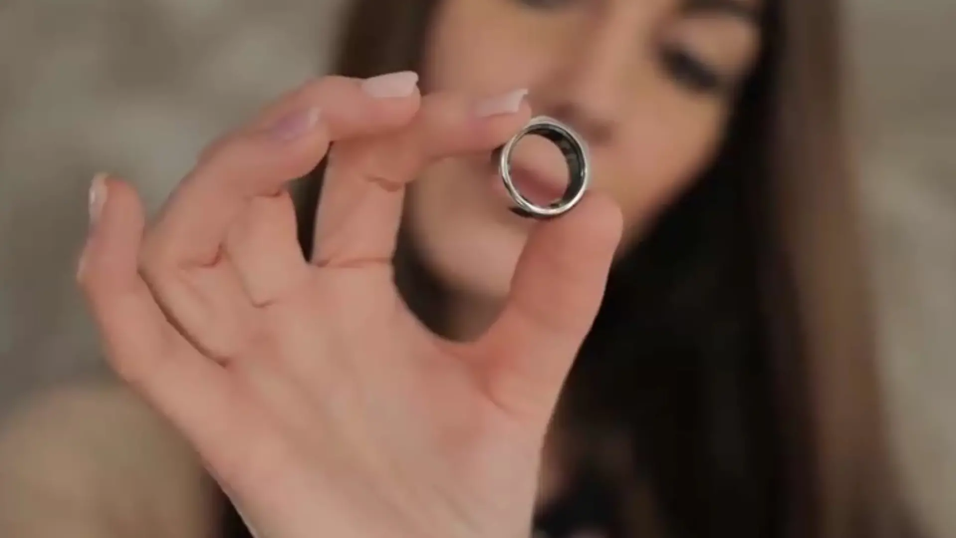 Eine Frau hält einen Health Tracking Ring in die Kamera.