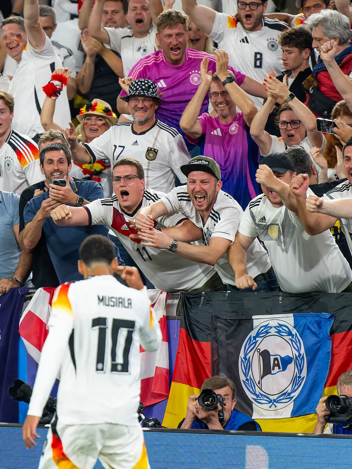Der deutsche Fußball-Nationalspieler Jamal Musiala jubelt nach einem Tro im EM-Spiel gegen Dänemark, die Deutschen Fans flippen fast aus.