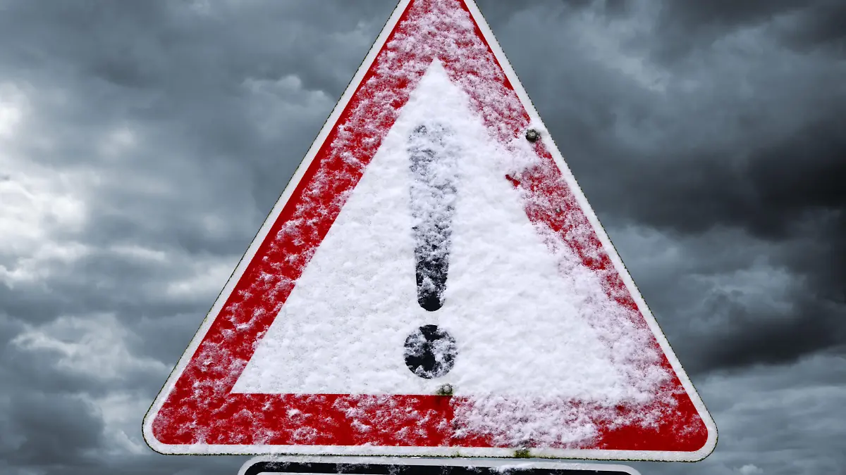 Verschneites Schild mit Ausrufezeichen, Symbolfoto Schneeglätte, Glatteis und winterliche Straßenverhätnisse, Fotomontage