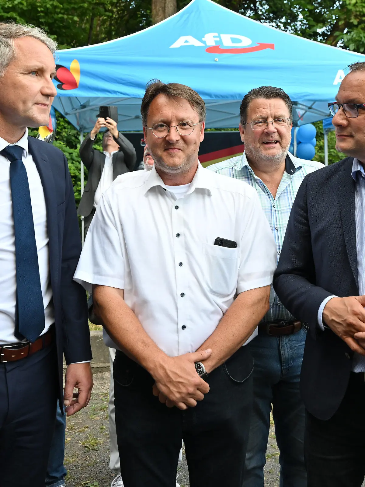 25.06.2023, Thüringen, Sonneberg: Björn Höcke (AfD, l), Robert Sesselmann (AfD,M), Stephan Brandner (AfD, 3.v.l.) und Tino Chrupalla (AfD,2.v.r) stehen im Garten des Restaurants Frankenbaude bei der AfD-Wahlparty. Der ehemalige Landrat Hans-Peter Schmitz (parteilos) war aufgrund einer langwierigen Erkrankung in den Ruhestand versetzt worden. Der AfD-Abgeordnete Robert Sesselmann hatte in der ersten Runde die meisten Stimmen erhalten. Er wäre der erste AfD-Landrat in Deutschland. In der Stichwahl tritt er gegen Jürgen Köpper (CDU) an. Foto: Martin Schutt/dpa +++ dpa-Bildfunk +++