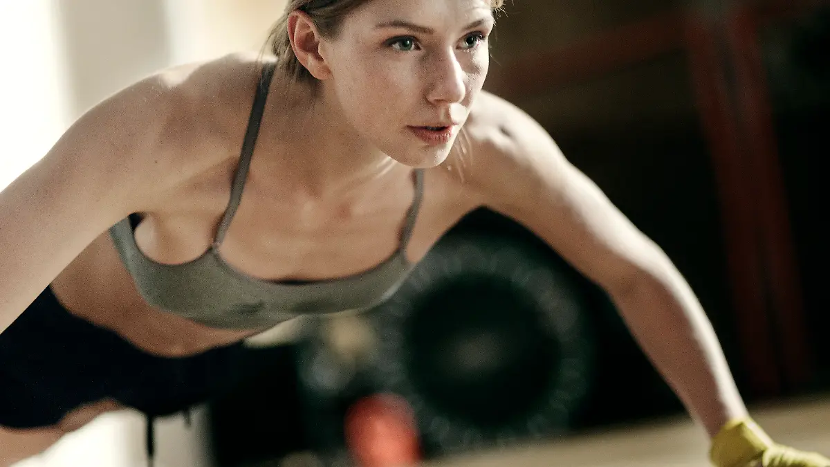 Frau in Sportkleidung macht Liegestütze.