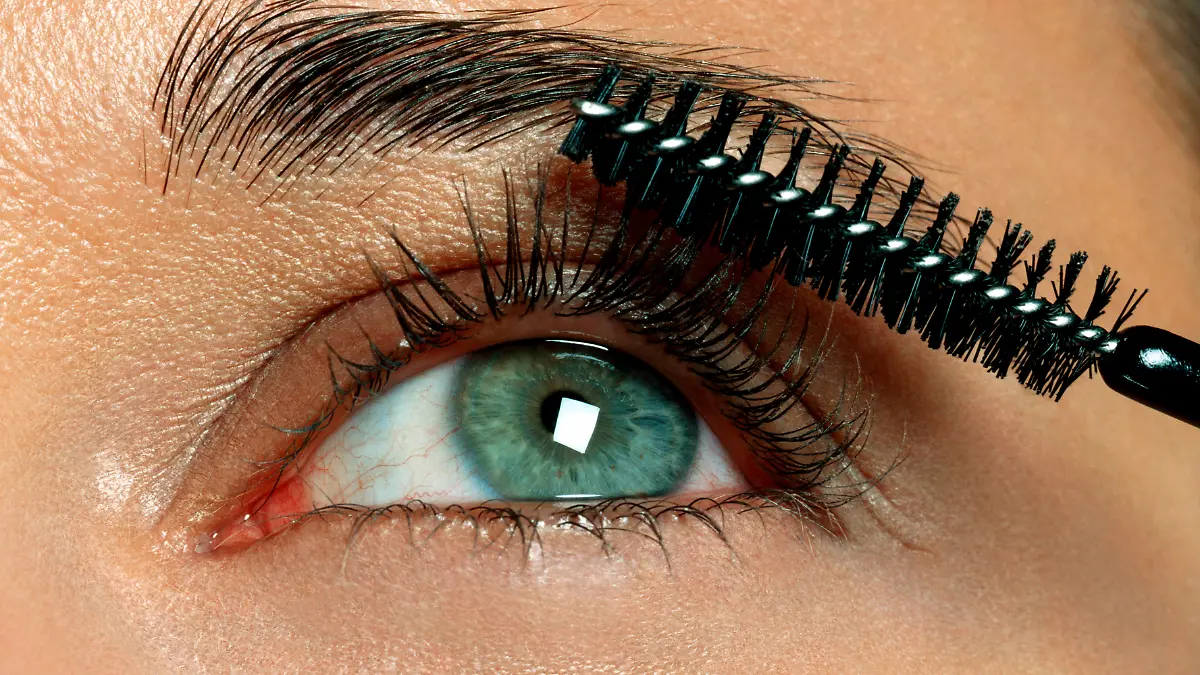 Grüne Augen werden mit brauner Mascara geschminkt.